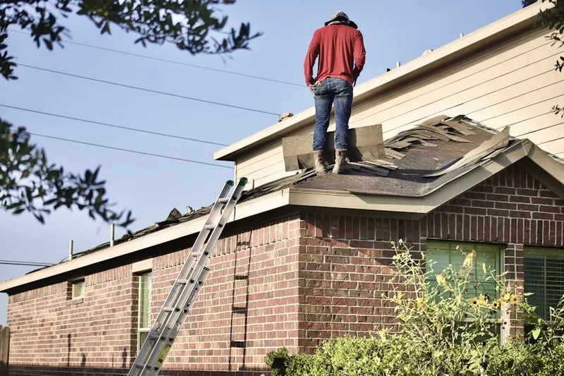 Professional roofer working on a residential roof in University Estates